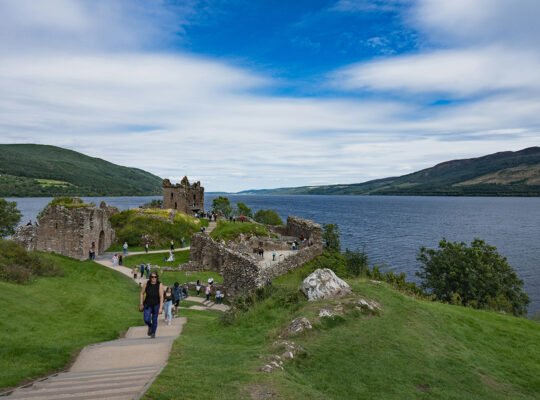 Urquhart Castle ruins on Loch Ness shoreline with visitors