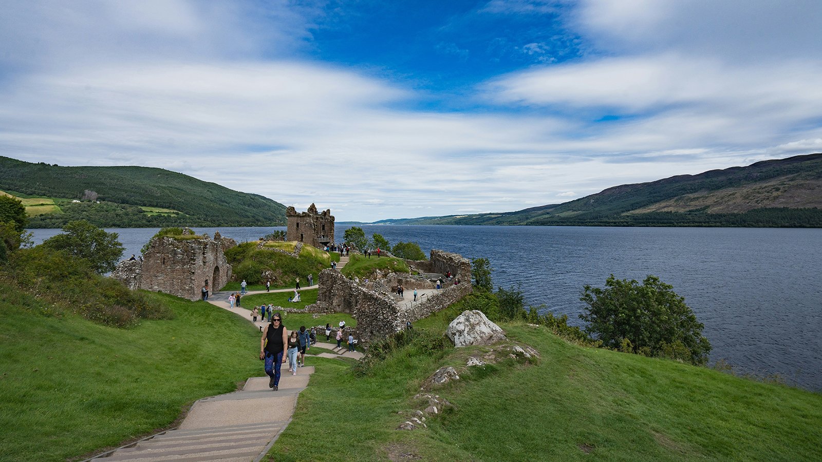 Urquhart Castle ruins on Loch Ness shoreline with visitors