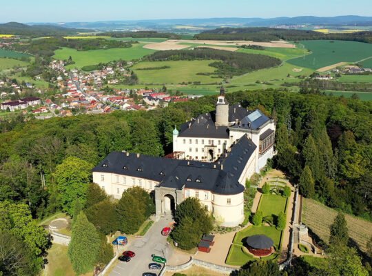 Aerial view of Zbiroh Castle amid forest and fields