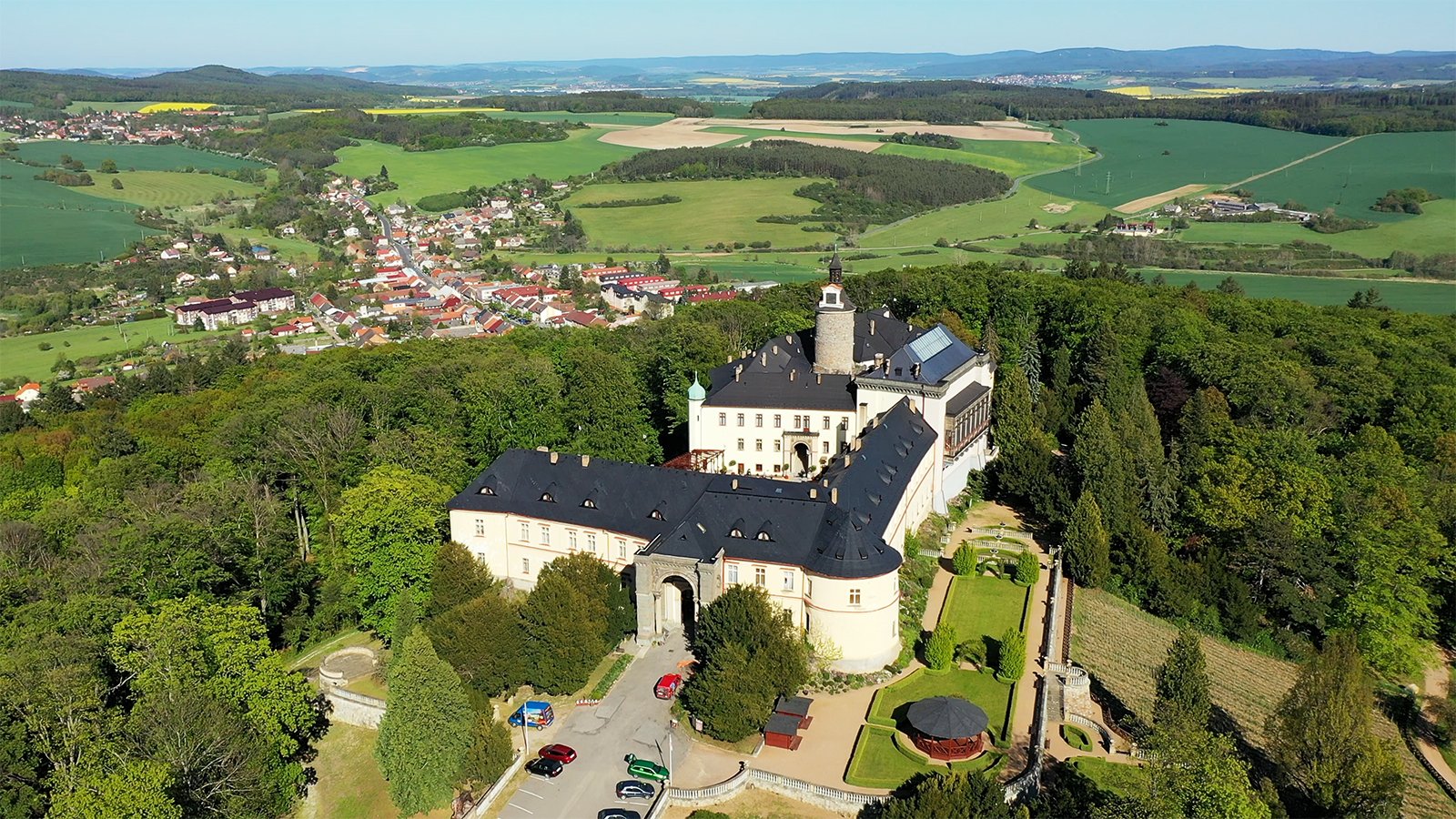 Aerial view of Zbiroh Castle amid forest and fields