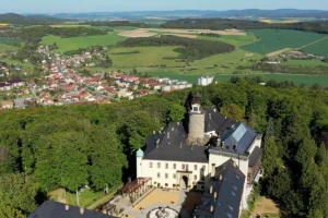 Aerial view of Zbiroh Castle surrounded by forest and nearby village