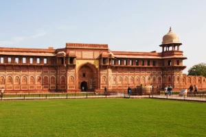Agra Fort red sandstone façade and central archway with garden in foreground