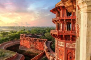Agra Fort red sandstone bastion at sunrise overlooking green landscape