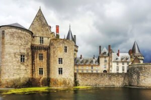Moated Château de Sully-sur-Loire under stormy sky