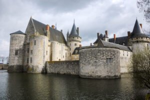 Château de Sully-sur-Loire seen from moat under cloudy sky