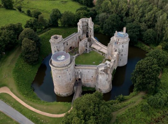 Aerial view of Hunaudaye Castle surrounded by moat and trees