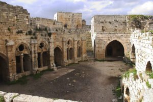 Courtyard and stone arches of Krak des Chevaliers under cloudy sky