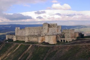 Krak des Chevaliers on hilltop under cloudy sky