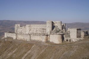 Krak des Chevaliers fortress on hill, stone walls and towers