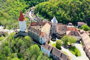 Aerial view of Krivoklat Castle perched above a forested valley
