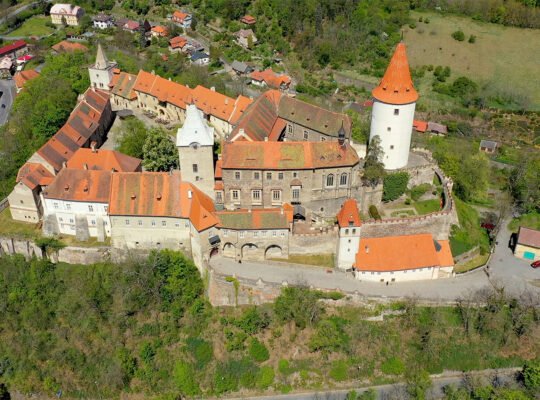 Aerial view of Krivoklat Castle perched above wooded valley
