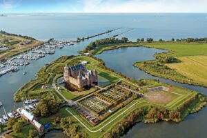 Aerial view of Muiderslot Castle on moat island with gardens and marina