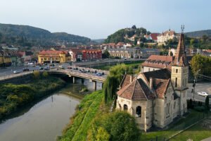 View of Sighișoara Citadel on hill with bridge and river