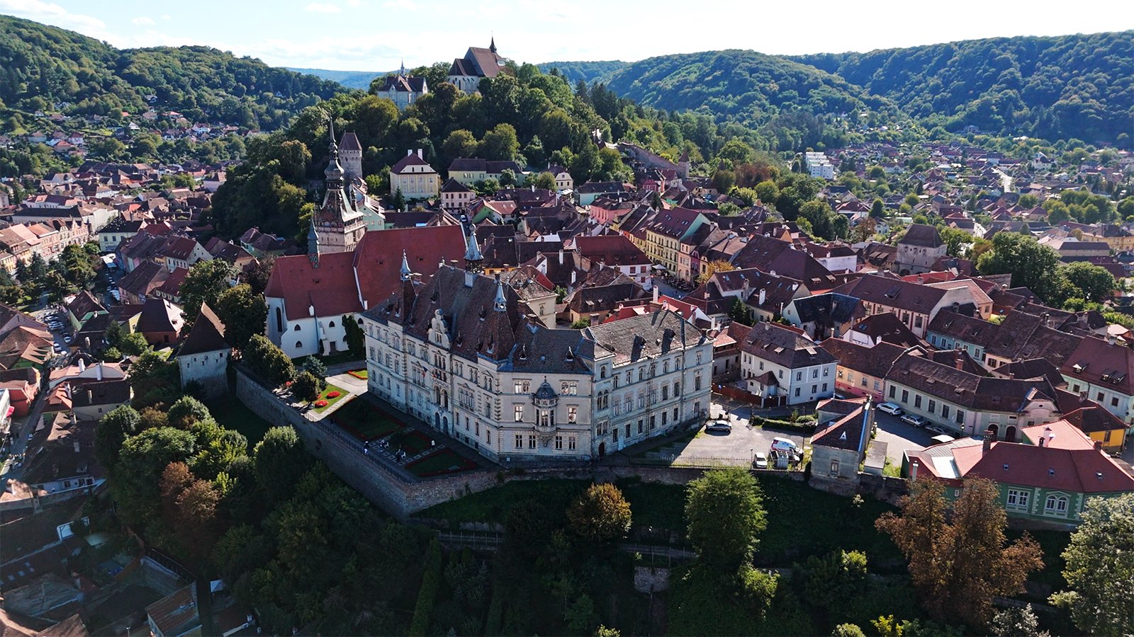 Aerial view of Sighișoara Citadel atop forested hill