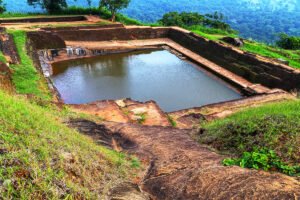 Ancient Sigiriya rock pool and surrounding jungle ruins