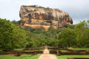 Sigiriya rock fortress rising above lush gardens and ruins
