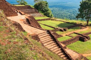 Ancient brick terraces and stone steps at Sigiriya rock fortress overlooking jungle