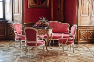 Ornate red salon with antique chairs at Valtice Castle