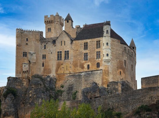 Château de Beynac perched on limestone cliffs against blue sky