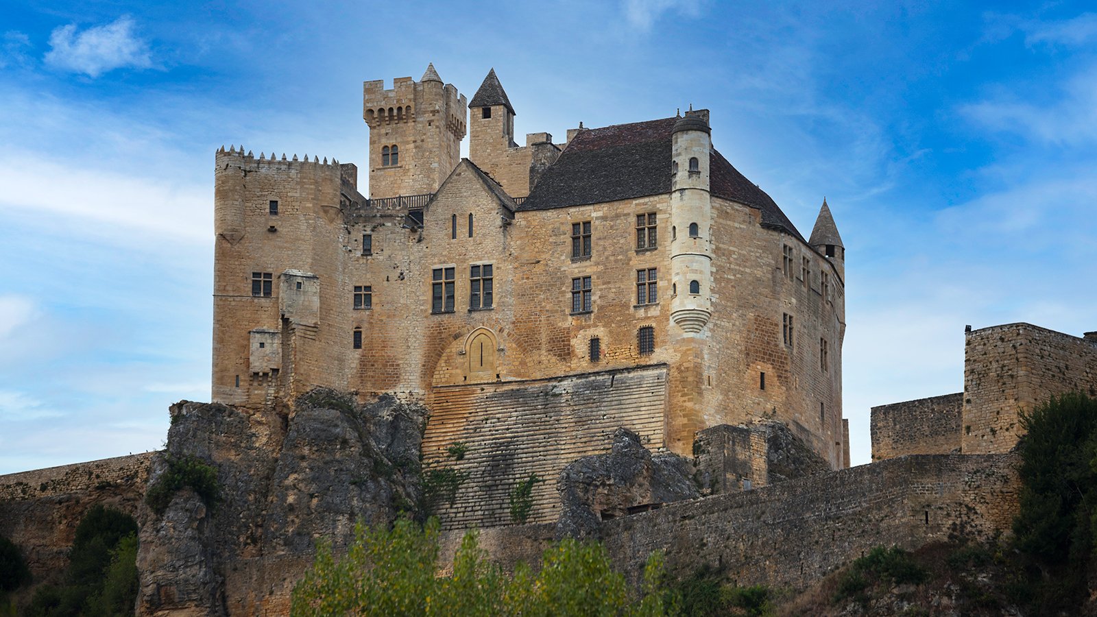 Château de Beynac perched on limestone cliffs against blue sky