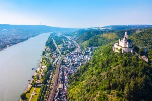 Marksburg Castle atop green hill beside the Rhine River