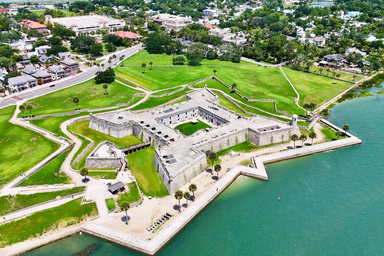 High-angle aerial view of Castillo de San Marcos in St. Augustine, Florida, highlighting its star-shaped fortification, surrounding city streets, and waterfront.